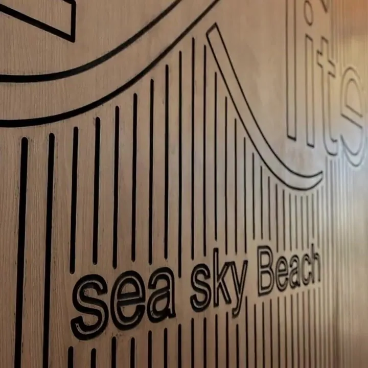 The carved wooden Sea Sky Beach sign