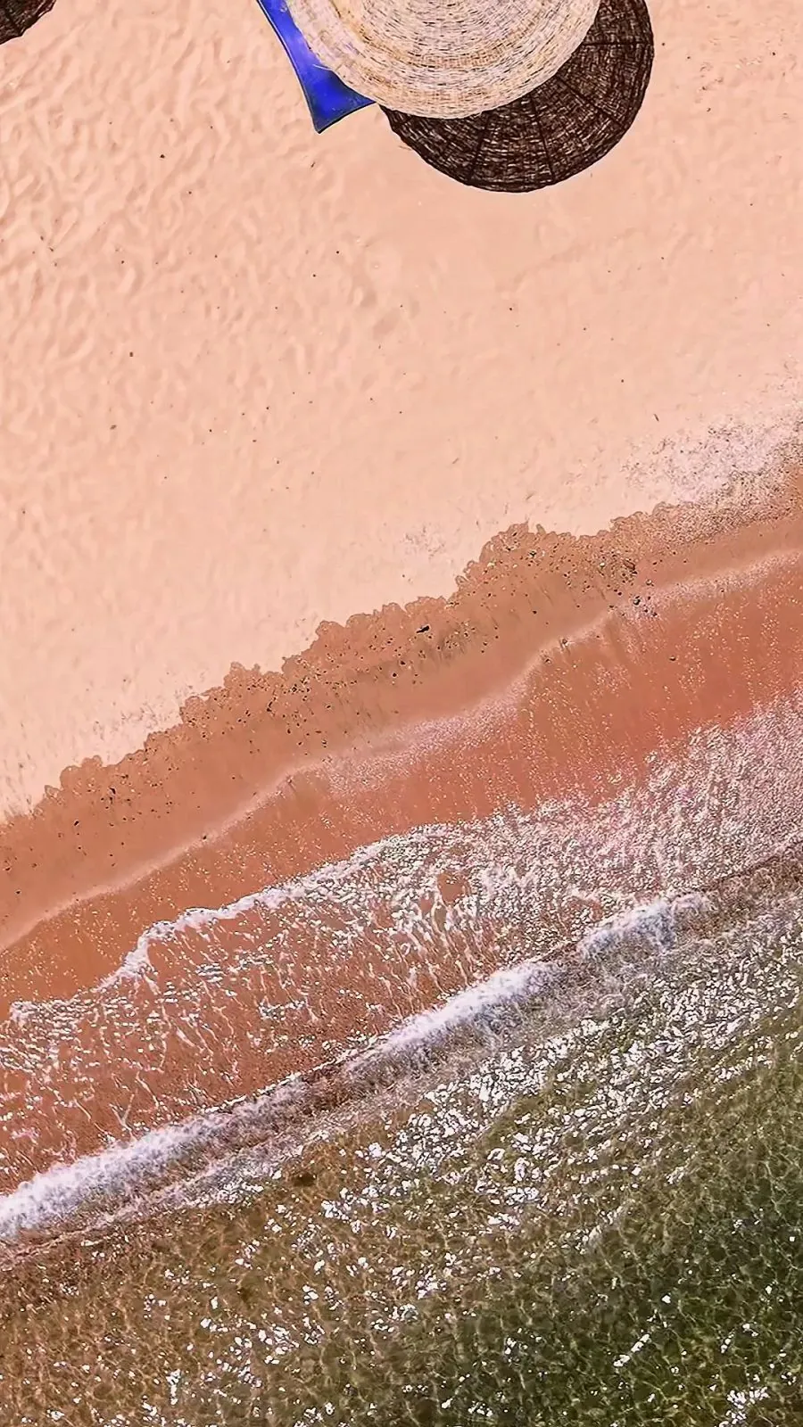Der Strand von oben: goldener Sand und die ersten Wellen