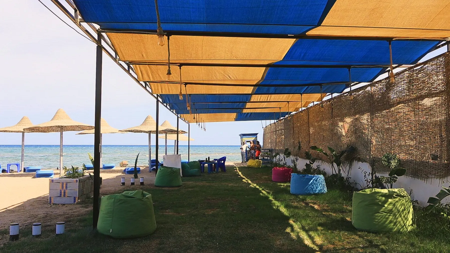 Der neue Strandgarten: Rasen, bunte Sitzsäcke und Sonnensegel bis hin zum Meer