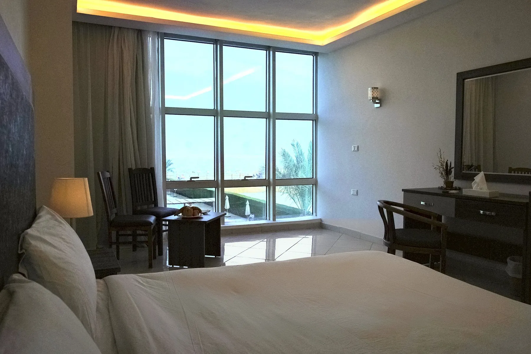 Superior-Zimmer mit raumhohem Fenster und Blick auf Meer und Pools
