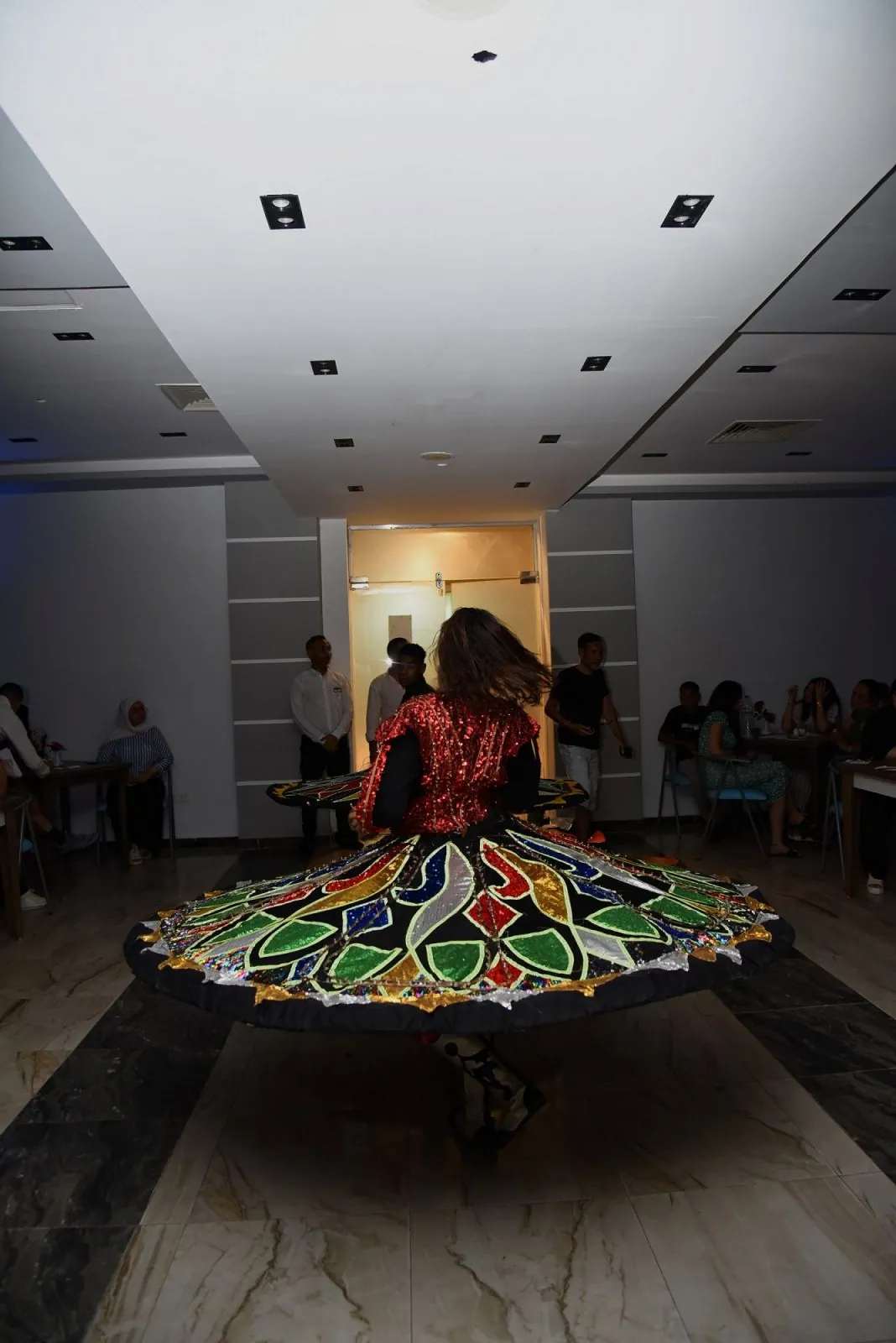 A tanoura dancer spinning in a wide, coloured skirt